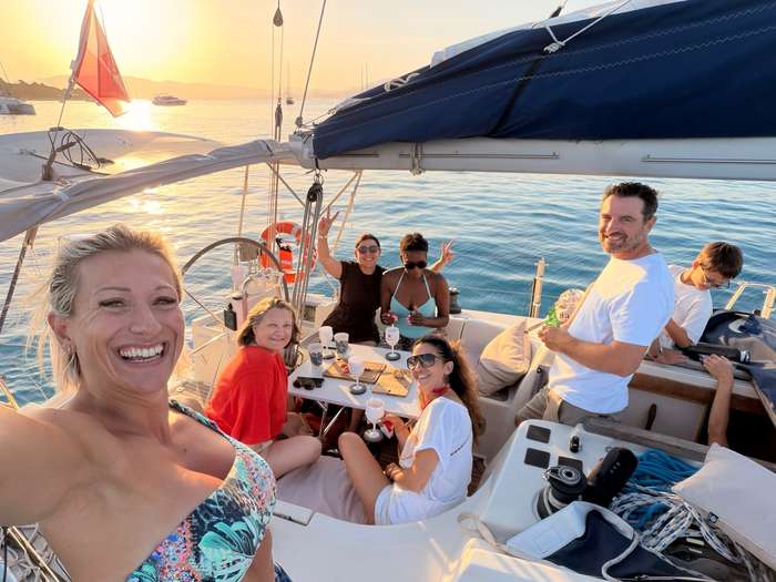 Group of friends aboard a sailboat at sunset