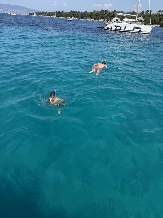 Swimmer in turquoise water next to a boat